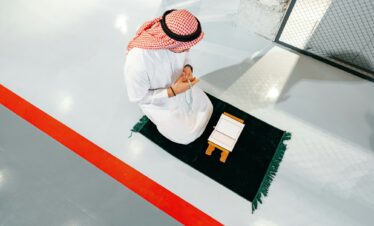 Young arab muslim man reading the holy Quran in the office