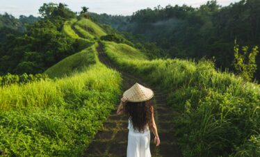 Young beautiful woman walking on Campuhan Ridge way of artists, in Bali, Ubud